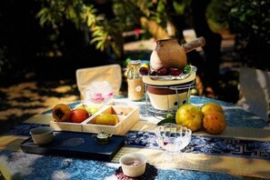 A table set outdoors with fruits, a jug, and a teapot. - Yangshuo Moon Villa Homestay (Yulonghe Scenic Area Branch) (Yangshuo)