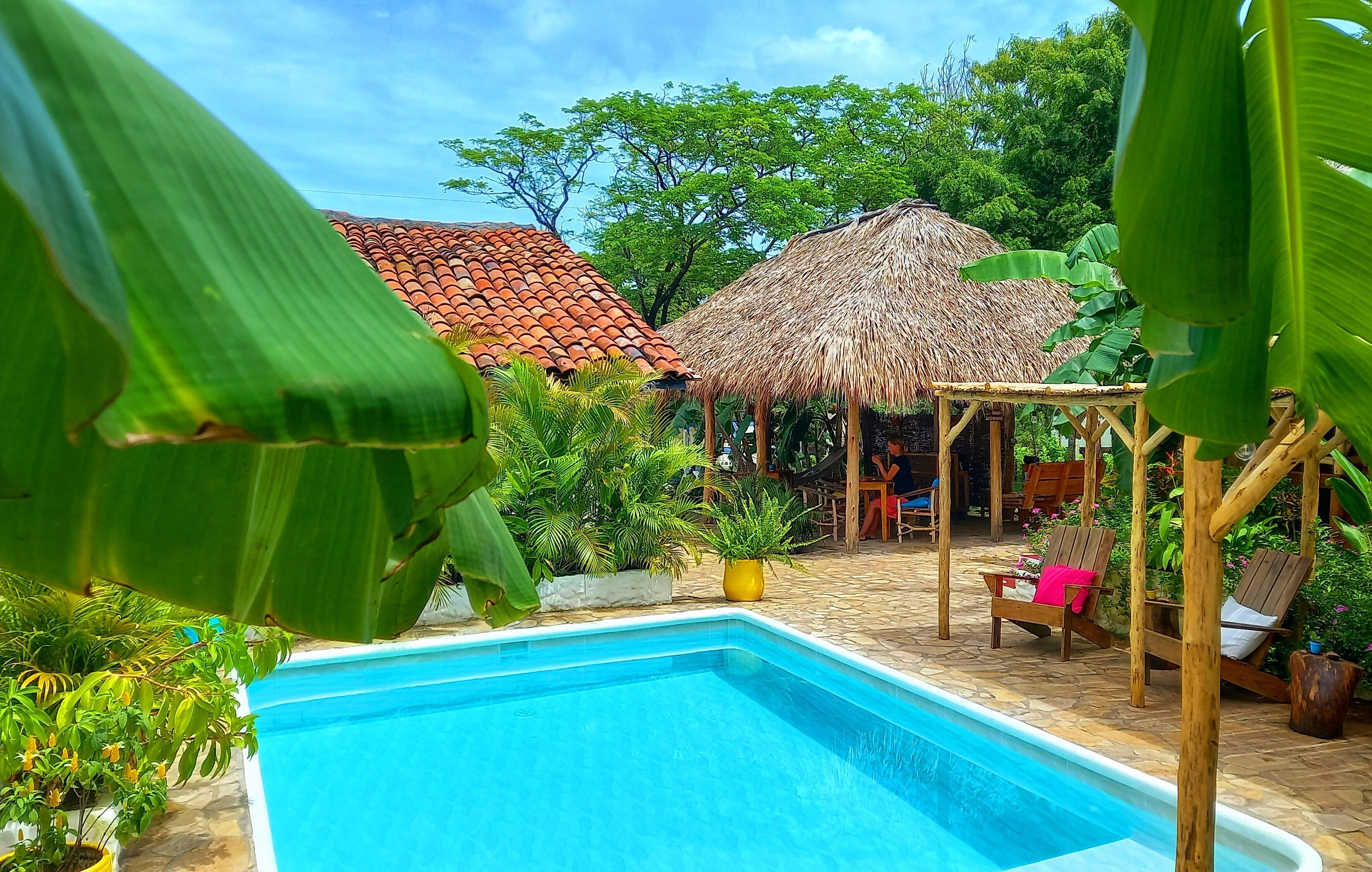 Una piscina al aire libre, sillones reclinables de piscina