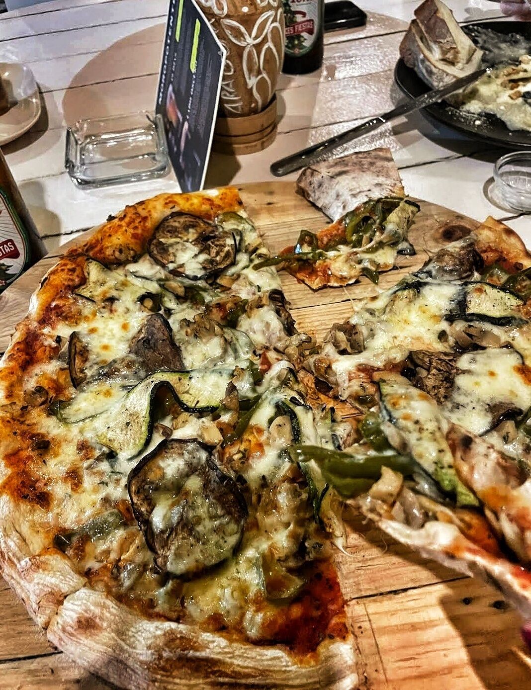 A pizza with various toppings on a wooden board.