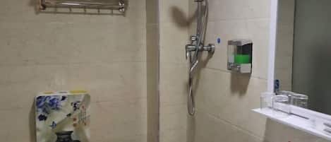 Baño con ducha, inodoro, lavabo y toallero.