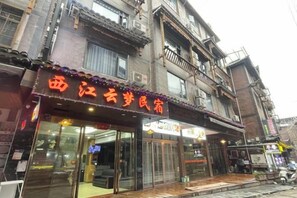 A building with a storefront featuring a sign with Chinese characters. - Xijiang Anxia B&B (Leishan)