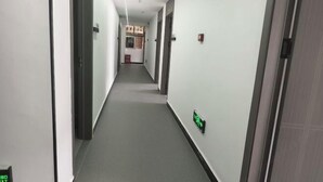 A narrow, well-lit hallway with a carpeted floor, white walls, and a door at the end. - Xijiang Anxia B&B (Leishan)