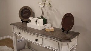 Un aparador con cajones, un espejo y un plato decorativo encima.