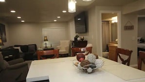 Un comedor con una mesa blanca, sillas y un centro decorativo.