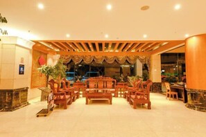 A lobby with a central seating area, a reception desk, and a large window. - Yunti Hotel (Lvchun)