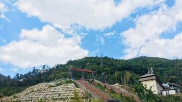 A terraced garden with a red structure on a hillside.