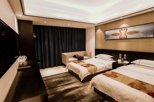 Habitación de hotel con dos camas, un escritorio, una silla, un cuadro grande y una cortina oscura.
