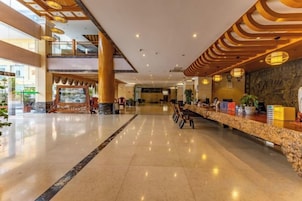 Un vestíbulo amplio con mostrador de recepción, zona de estar y vistas al área exterior.