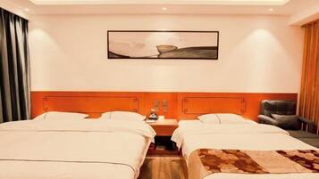 Quarto de hotel com duas camas, uma mesa de cabeceira, uma cadeira e um quadro na parede.