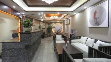 A reception area with a stone counter, a sofa, and a coffee table.
