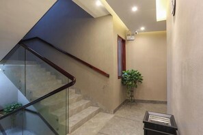 A hotel interior with a glass staircase, a plant, and a reception desk. - Yueshe Boutique Hotel (Huangyao Ancient Town) (Zhaoping)