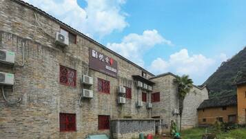 A traditional brick building with multiple windows and air conditioning units.
