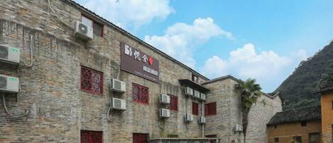 A traditional brick building with multiple windows and air conditioning units.