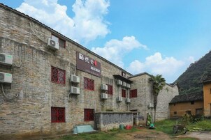 Un edificio tradicional de ladrillo con varias ventanas y unidades de aire acondicionado.