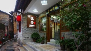 A traditional-style building with a stone facade, a wooden door, and a signboard. - Yueshe Boutique Hotel (Huangyao Ancient Town) (Zhaoping)