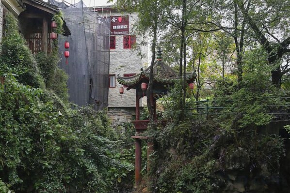 A traditional building with a stone facade, a wooden structure with a tiled roof, and a sign with Chinese characters. - Yueshe Boutique Hotel (Huangyao Ancient Town) (Zhaoping)