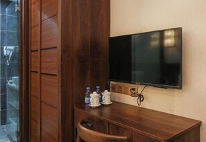A wooden desk with a television, a chair, and a small table with cups and bottles. - Yueshe Boutique Hotel (Huangyao Ancient Town) (Zhaoping)