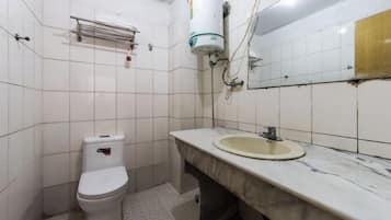Un baño con inodoro, lavamanos y espejo.