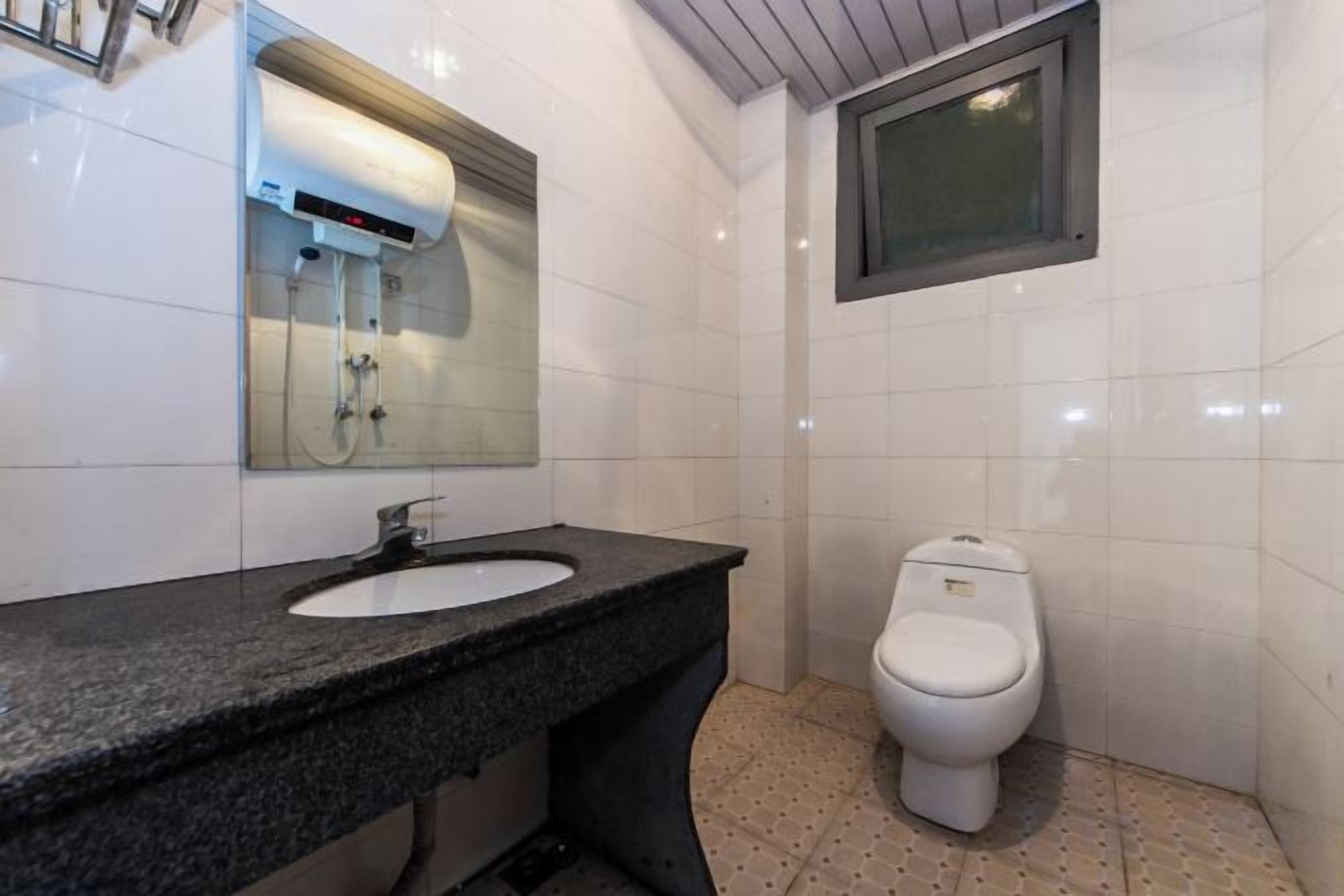A bathroom with a sink, mirror, and toilet.