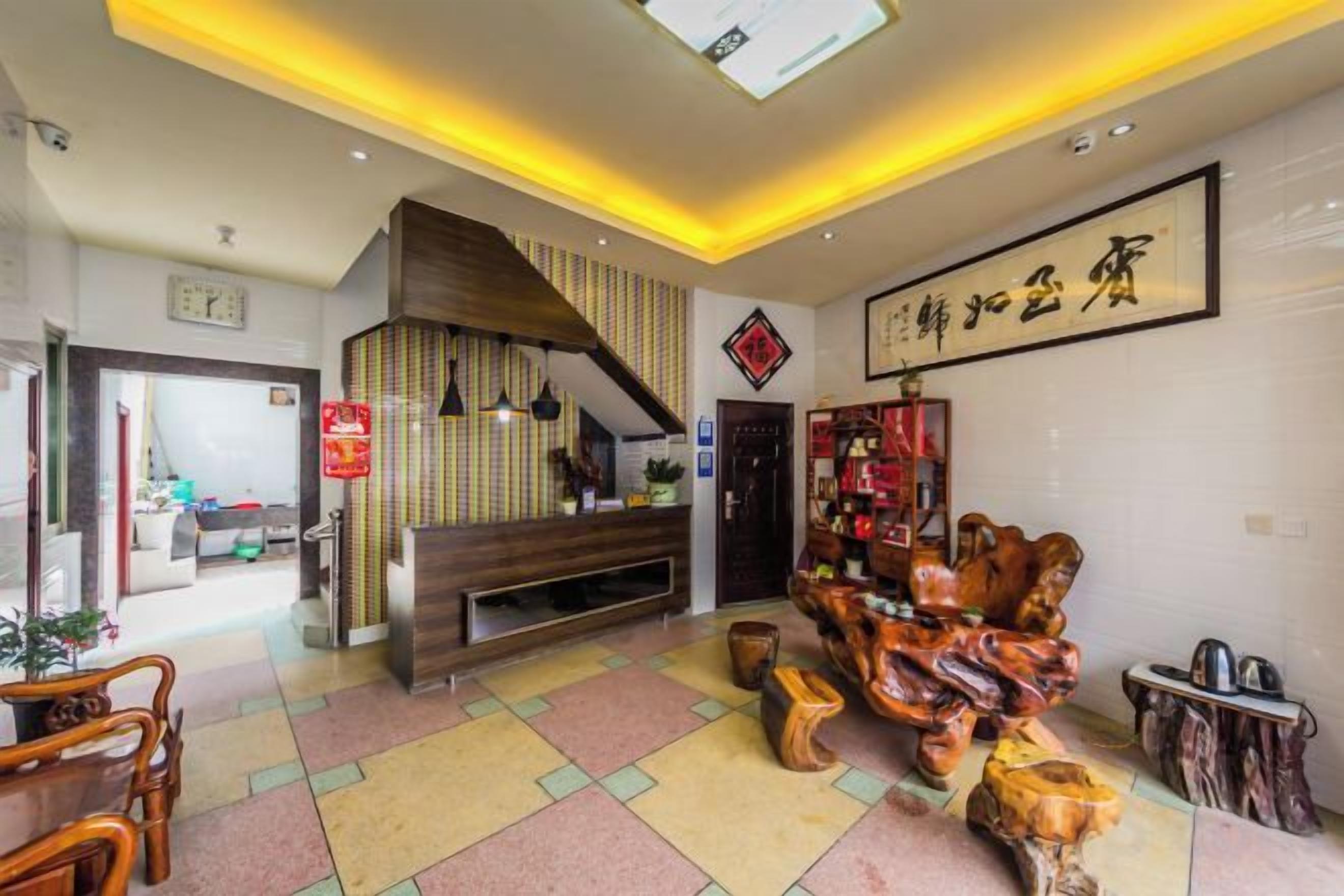 Un vestíbulo de hotel con una recepción, una escalera y una escultura de madera tradicional.