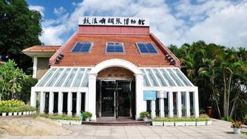 A building with a red roof, a glass entrance, and a sign in a foreign language.