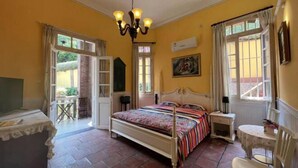 A bedroom with a bed, a chair, a table, and a chandelier. - Chuanwu Old Villa Family Hotel (Xiamen)