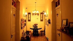 A hallway with a dining table and chairs, a chandelier, and framed pictures on the walls. - Chuanwu Old Villa Family Hotel (Xiamen)