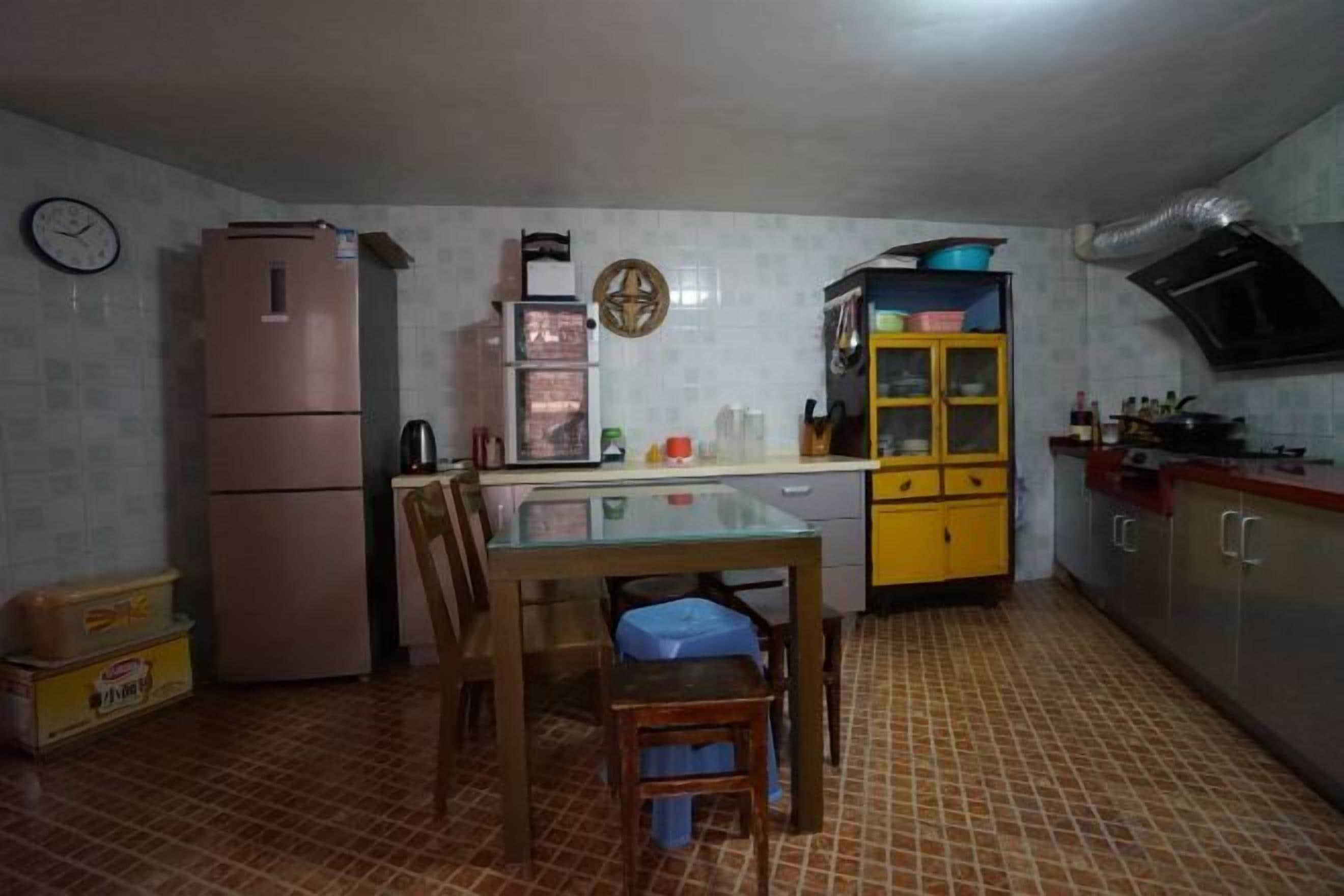 A compact kitchen with a refrigerator, microwave, and a small dining table with chairs.