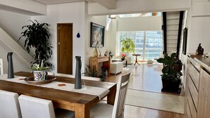 A modern living room with a wooden dining table, white sofas, and a large window offering a view of the city. - Great view, big space, best location in Mexico City—5min from lot of attractions (Mexico City)