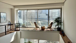 A spacious balcony with large windows, two wooden chairs, and a potted plant. - Great view, big space, best location in Mexico City—5min from lot of attractions (Mexico City)