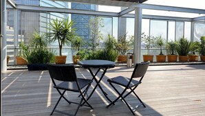 A rooftop terrace with a wooden deck, two black wicker chairs, a small round table, and potted plants. - Great view, big space, best location in Mexico City—5min from lot of attractions (Mexico City)