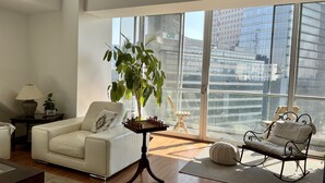 A spacious living room with a large window, a white sofa, a small table with a chessboard, and a potted plant. - Great view, big space, best location in Mexico City—5min from lot of attractions (Mexico City)