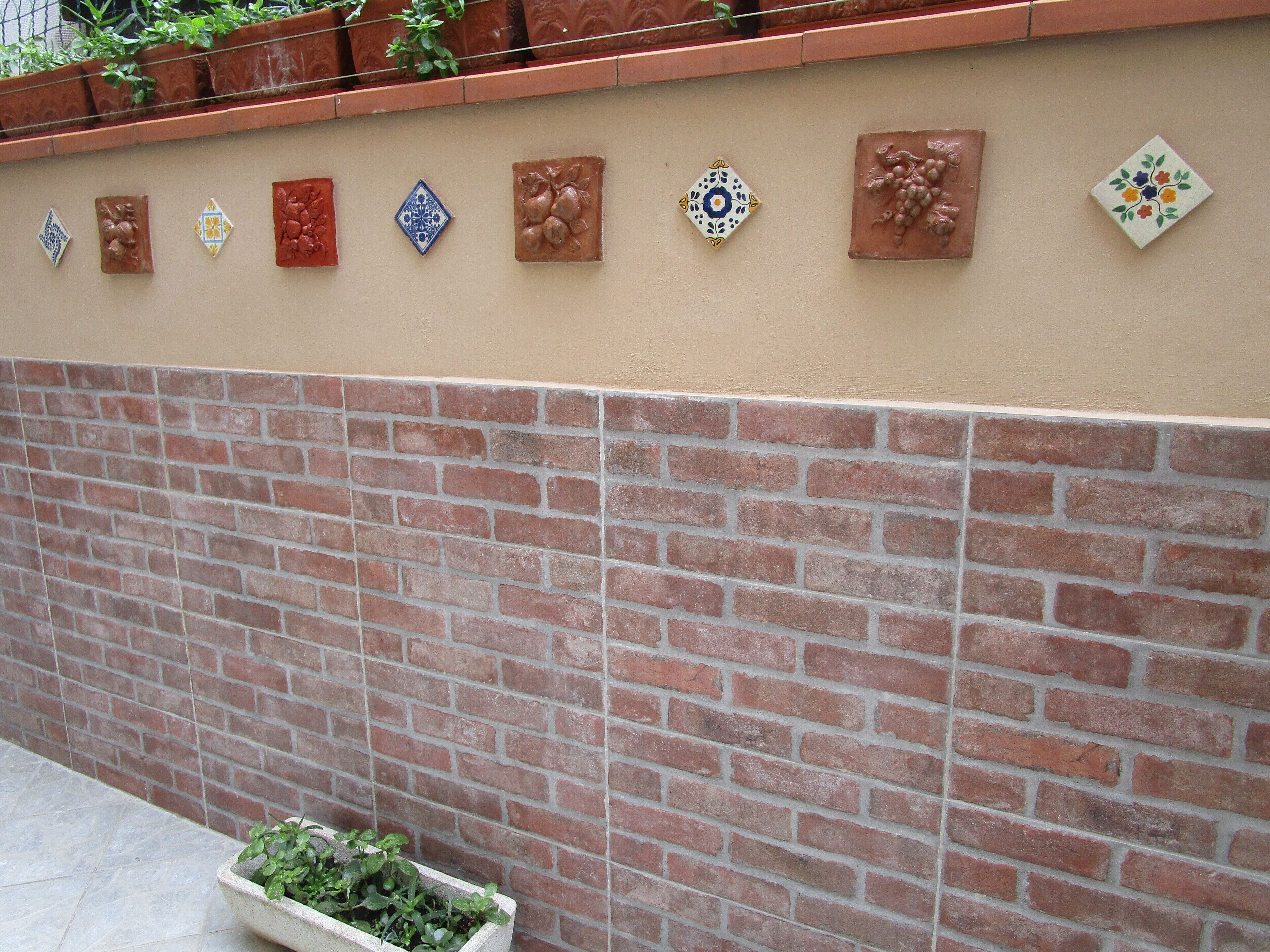 Un mur avec un motif en briques et des carreaux décoratifs.