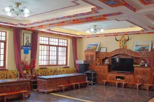 Una habitación tradicional con un conjunto de sofá, una televisión y objetos decorativos.