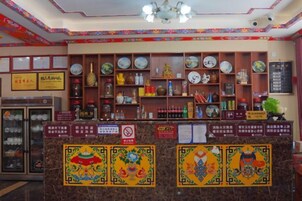 Un área de recepción con mostrador, estanterías con diversos artículos y un refrigerador.