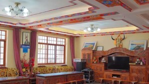 A traditional room with wooden furniture, a television, and decorative items on the walls. - Dawagengzha Ecological Theme Hotel (Baoxing)