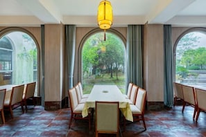 A dining area with a long table, chairs, and a hanging light fixture. - Guoqi Hotel (Tangchi Hot Spring Tourism Resort) (Lujiang)