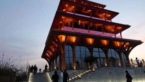 Un edificio moderno con un diseño arquitectónico único, que cuenta con varios niveles y grandes ventanales.