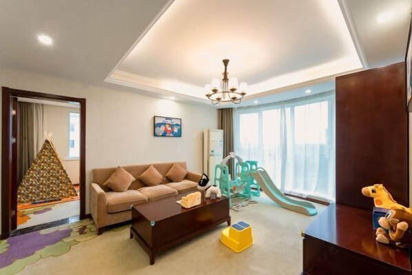 A living room with a sofa, coffee table, and children's play area including a slide.