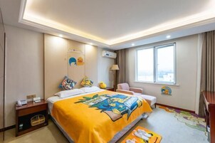 Habitación de hotel con cama, mesita de noche, lámpara, silla y ventana con cortinas.