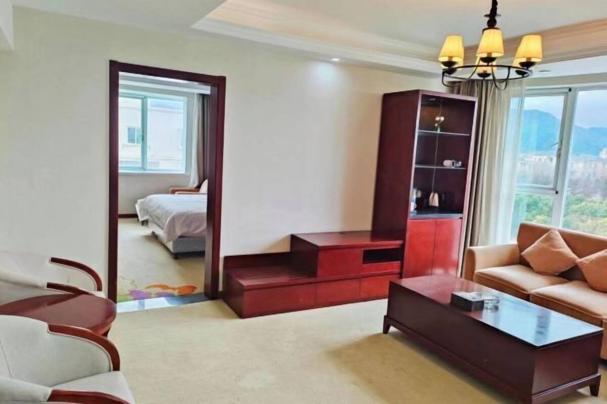 Une chambre d’hôtel comprenant un lit, un canapé, une table basse, une bibliothèque et une vue sur l’extérieur.