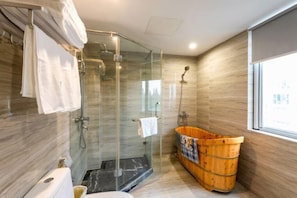 A modern bathroom with a glass-enclosed shower, a wooden bathtub, and a toilet. - Guoqi Hotel (Tangchi Hot Spring Tourism Resort) (Lujiang)