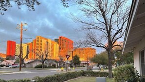 Ett bostadsområde med moderna lägenhetsbyggnader, en väg med en väjningspliktsskylt och en uteplats med utemöbler.