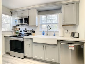 A modern kitchen with stainless steel appliances, a built-in oven, and a dishwasher.