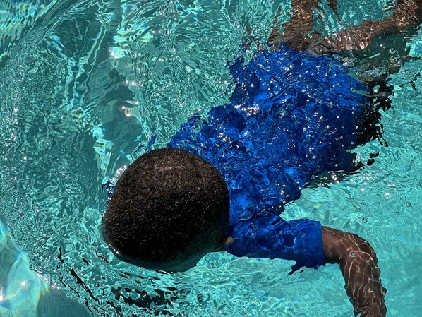 Una persona nadando en una piscina.
