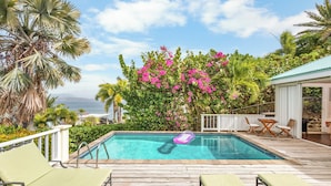 A pool with lounge chairs, surrounded by lush greenery and a view of the ocean. - 4 Bedroom Villa in Calypso Bay Resorts with Fabulous Ocean View and Private Pool (Frigate Bay)