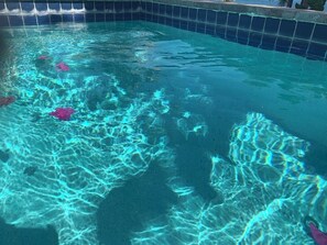 A clear pool with visible water patterns and a tiled edge.