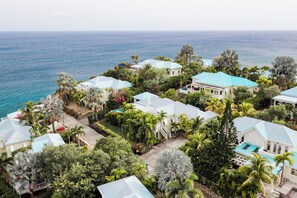 Un barrio residencial costero con casas, una piscina y vistas al océano.