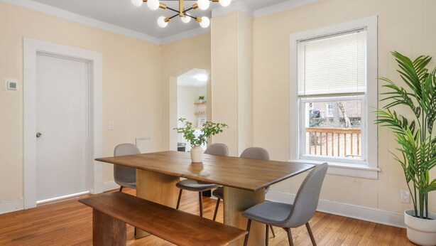 Un comedor con una mesa de madera, seis sillas y un banco.