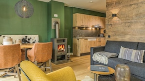 Une cuisine moderne avec des meubles en bois, une cuisinière encastrée et un coin repas doté de chaises en cuir.